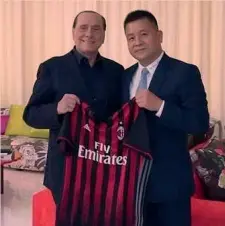  ??  ?? Silvio Berlusconi consegna a Li Yonghong una maglia rossonera