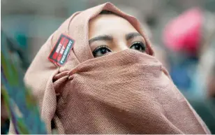  ??  ?? أمريكية مسلمة تشارك في مسيرة حاشدة ضد الرئيس األمريكي في نيويورك أمس.