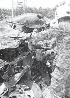  ??  ?? Fire and Rescue Department personnel freeing the passenger trapped in the Ford Ranger.