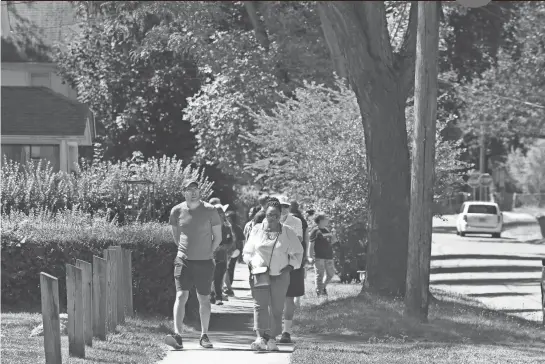  ?? SHAWN DOWD/DEMOCRAT AND CHRONICLE ?? Democrat and Chronicle reporter Justin Murphy, left, helps lead a walk around the Marketview Heights neighborho­od during the Marketview Heights Tree Canopy Initiative guided neighborho­od walk held July 9, 2022 in Rochester.