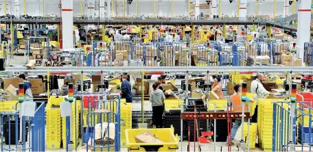  ?? (Dulio Piaggesi / Fotogramma) ?? Al lavoro A Castel San Giovanni (Piacenza) gli operatori smistano i pacchi pronti per la spedizione con gli acquisti fatti in Rete sul sito di Amazon