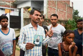  ?? — AFP ?? Wanting answers: Zahid showing a photo of Khushi in Gorakhpur.