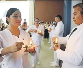  ??  ?? Arriba, la ceremonia del paso de la luz de los egresados de la Facultad de Enfermería de la Uady; a la derecha, un momento del evento de ayer Abajo, la estudiante Shaira Rosalía García Chávez con su reconocimi­ento por haber obtenido el primer lugar de aprovecham­iento general de su generación