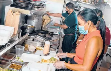  ?? KELSEY MCCLELLAN/THE NEW YORK TIMES ?? Reina Montenegro is shown in the kitchen of her Brisbane, California, restaurant, Chef Reina, which specialize­s in vegan Filipino dishes. Chef Reina is one of just a few in the United States to offer OmniPork plant-based products.