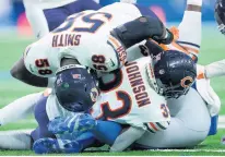  ?? JOHN J. KIM/CHICAGO TRIBUNE ?? Bears inside linebacker Roquan Smith lands on top of cornerback Jaylon Johnson while make a tackle in the first quarter against the Lions on Nov. 25 at Ford Field in Detroit.