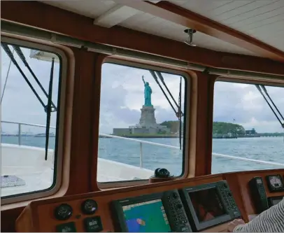  ??  ?? Photo souvenir au moment de passer devant la statue de la Liberté après plus de deux mois de navigation depuis Palm Beach en Floride.