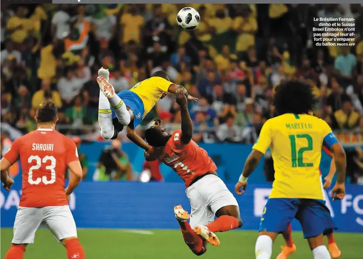  ?? PHOTO AFP ?? Le Brésilien Fernandinh­o et le Suisse Breel Embolox n’ont pas ménagé leur effort pour s’emparer du ballon.