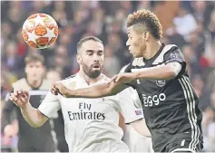  ?? — AFP photo ?? Ajax’s David Neres (right) vies for the ball with Real Madrid’s Dani Carvajal during the second leg match at the Santiago Bernabeu stadium in Madrid.