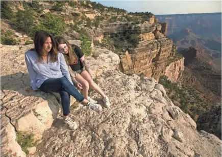  ?? DAVID WALLACE/USA TODAY NETWORK ?? Laura Trujillo of Cincinnati sits on an overlook in Grand Canyon National Park with her daughter Lucy Faherty. Trujillo’s mother killed herself at the Grand Canyon in April 2012.