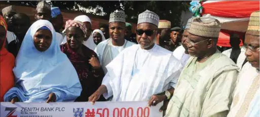  ??  ?? Governor Masari awarding N50, 000 each to the Female Teacher Trainee Scholarshi­p Scheme beneficiar­ies