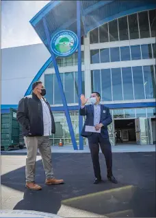  ?? Bobby Block/The Signal ?? (Above) Santa Clarita Assistant City Manager Frank Oviedo, right, conducts a tour of The Cube ice rink Tuesday with General Services Manager Cruz Caldera. (Below) The renovated ice rink in Valencia. (Inset) The Cube ice rink logo is seen up close.