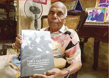  ??  ?? Datuk R. Thambipill­ay with a copy of ‘The Last Post’, in which he wrote about the Malayan Emergency.