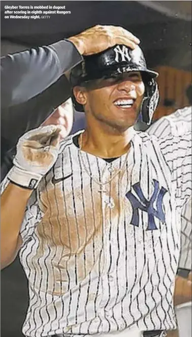  ?? GETTY ?? Gleyber Torres is mobbed in dugout after scoring in eighth against Rangers on Wednesday night.