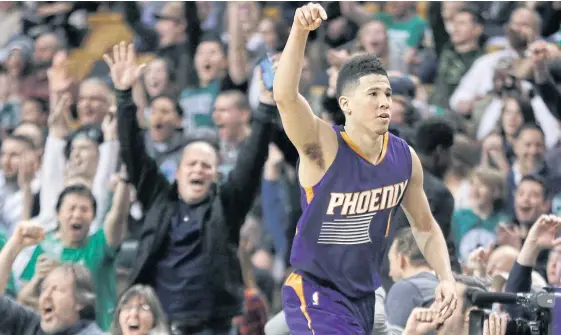  ??  ?? Suns guard Devin Booker gestures after scoring a basket in the fourth quarter against the Celtics.