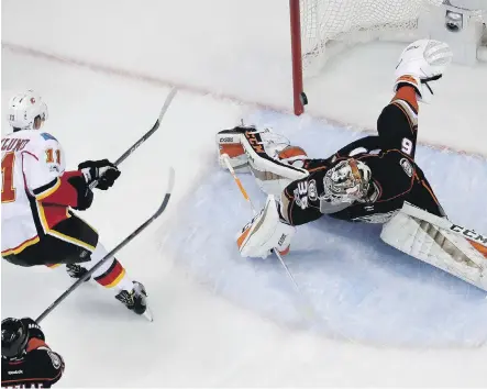  ?? CHRIS CARLSON ?? Calgary Flames’ Mikael Backlund scores past Anaheim Ducks goalie John Gibson during Game 2 action in their playoff series in Anaheim. Gibson has been a Flames’ nemesis so far in the series with the Ducks up 2-0 heading into Monday’s Game 3 in Calgary.