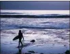  ?? ASSOCIATED PRESS ?? IN THIS JULY 2 FILE PHOTO, a surfer walks out of the water after riding waves at Scripps Beach in San Diego.