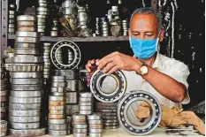  ?? AFP ?? A shopkeeper displays bearings in Chennai. India’s reopening has allowed businesses to get back to work.