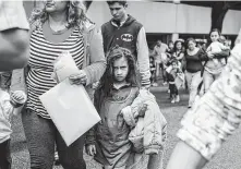  ?? Veronica G. Cardenas / ?? Asylum-seekers walk from the McAllen bus station to the Humanitari­an Respite Center, where they can shower, change into clean clothes and eat after being processed.