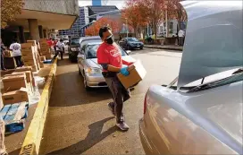  ?? STEVE SCHAEFER FOR THE AJC ?? A volunteer loads boxes of food into cars outside the World Congress Center during the annual Hosea Williams Thanksgivi­ng Dinner on Thursday.