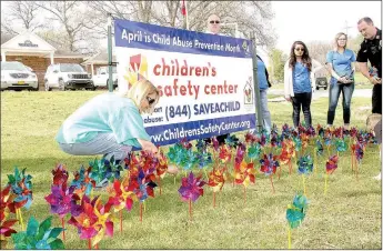  ?? LYNN KUTTER ENTERPRISE-LEADER ?? Gina Lyle-Bailey, a Prairie Grove City Council member, sticks a pinwheel in the ground last week in front of Prairie Grove City Hall. The Children’s Safety Center of Springdale used the pinwheels to bring attention to Child Abuse Prevention Month. The...