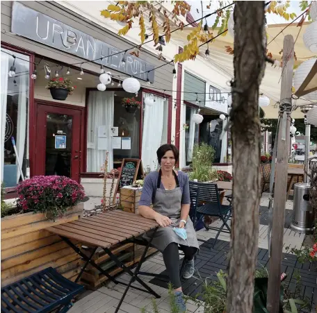  ?? MARY SCHWALM / BOSTON HERALD ?? WICKED WINTER: Erin Miller, owner of Urban Hearth, poses for a photo as she sits in her outdoor dining space that is complete with heaters, lights, lanterns, and barriers on Saturday in Cambridge. Miller, along with other restaurant owners, worries that the cold weather may slash the outdoor dining that they have relied on.