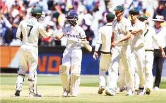  ?? — AFP photo ?? India’s captain Ajinkya Rahane (second left) bumps fists with Australia’s captain Tim Paine at the end of the second cricket Test match between Australia and India at the MCG in Melbourne.