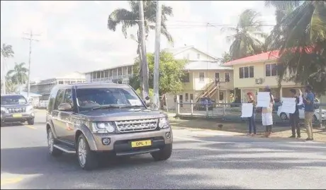  ??  ?? Prince Harry, in the British High Commission vehicle, is driven past the protestors.