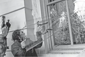  ?? U.S. DEPARTMENT OF JUSTICE ?? A rioter uses a shield belonging to U.S. Capitol Police to break open a window at the Capitol.