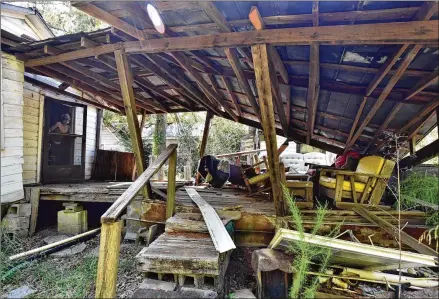  ?? HYOSUB SHIN / HYOSUB.SHIN@AJC.COM ?? Larry Burkes looks out in September at the back porch of his Randolph County home, severely damaged from Hurricane Michael in 2018. His home is one of many wrecked by the storm that raked the southwest Georgia area. His county, due to factors such as poverty in the area, is particular­ly vulnerable to natural disasters.