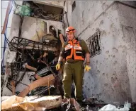  ??  ?? A rescue team member checks the site of a rocket strike from the Gaza Strip which hit buildings in Ashdod, Israel