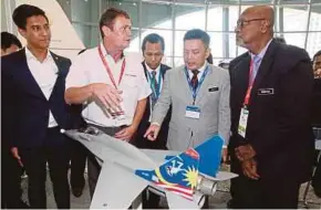  ?? PIC BY MOHD YUSNI ARIFFIN ?? SME Aerospace chief executive officer David F.J. Davies (second from left) briefing Internatio­nal Trade and Industry Minister Darell Leiking (second from right) and Deputy Rural Developmen­t Minister R. Sivarasa (right) at the Malaysia Aerospace Summit 2018 in Kuala Lumpur yesterday.