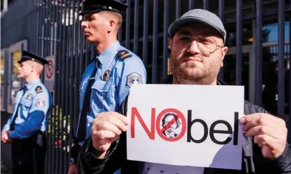  ??  ?? A Kosovo-Albanian man holds a placard featuring Handke’s face outside Sweden’s embassy in Pristina. Photograph: Armend Nimani/ AFP/Getty