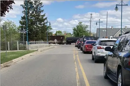  ?? LINDA GITTLEMAN — FOR THE MORNING SUN ?? Traffic waits for a train to pass on Monday at South State Street in Alma.