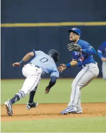  ?? BRIAN BLANCO/GETTY IMAGES ?? Mallex Smith of the Rays is caught in a rundown Sunday between the Jays’ Troy Tulowitzki and Devon Travis.