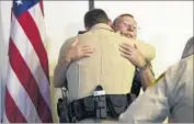  ?? Gina Ferazzi Los Angeles Times ?? IN LAS VEGAS, Clark County Assistant Fire Chief Larry Haydu, right, hugs Metropolit­an Police Sgt. Brandon Clarkson, whose brother was shot Sunday.