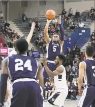  ?? Steve Musco / Yale Athletics ?? Yale’s Azar Swain launches a 3-pointer at the end of the first half Saturday against Penn.