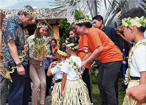  ?? — bernama ?? Warm welcome: orang asli children greeting Sultan Sharafuddi­n and Tengku Permaisuri norashikin during their visit to Carey Island.