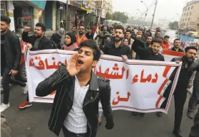  ?? Sabah Arar / AFP via Getty Images ?? Protesters carry a banner that reads, “The blood of martyrs is entrusted to us, it will not be in vain” during a march in Tahrir Square in the capital, Baghdad.