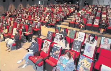  ??  ?? Visitors sit among movie posters to observe social distancing at an event discussing the South Korean zombie thriller
Peninsula.