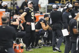  ?? Butch Dill / Associated Press ?? Drew Brees watched the second half from the sideline after suffering what the Saints said was a rib injury. He was hit hard by Kentavius Street, who was flagged for roughing the passer.
