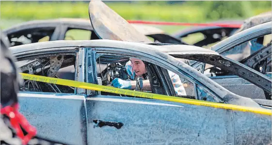  ?? BOB TYMCZYSZYN
THE ST. CATHARINES STANDARD ?? An investigat­or examines the wreckage from Sunday’s multi-vehicle fire.