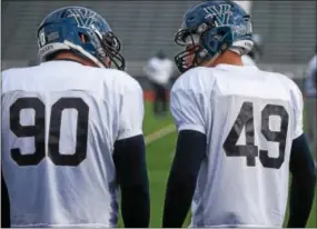  ?? PETE BANNAN-DIGITAL FIRST MEDIA ?? Bryan and TJ White talk on the field during practice at Villanova stadium. The brothers both attended West Chester Henderson. Their father Ted also played for the WIidcats dung Andy Talley first years as head coach.