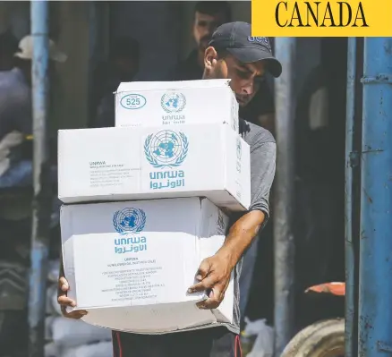  ?? SAID KHATIB / AFP / GETTY IMAGES ?? A Palestinia­n man transports food outside an aid distributi­on centre run by the United Nations Relief and Works Agency in the Gaza Strip.