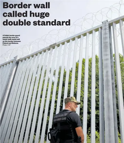 ?? Photo / AP ?? A Polish border guard patrols the area of a newly built metal wall on the border between Poland and Belarus.