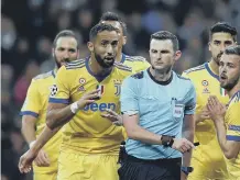  ??  ?? Michael Oliver is surrounded by Juventus players after awarding a penalty to Real Madrid in the Champions League. Photo: AP.