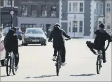  ?? Picture: Steve Parsons/PA Wire ?? PEDALLING ON Teenagers ride their bikes down a street in
Old Portsmouth after prime minister Boris Johnson put the UK in lockdown.