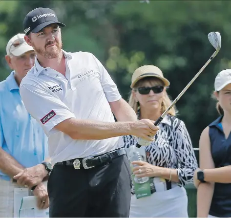  ?? TONY GUTIERREZ/THE ASSOCIATED PRESS ?? Jimmy Walker watches a chip shot during the first round of the PGA Championsh­ip golf tournament at Baltusrol Golf Club on Thursday. Walker shot a 65 to take the first-round lead. Martin Kaymer, Emiliano Grillo and Ross Fisher are one shot back.