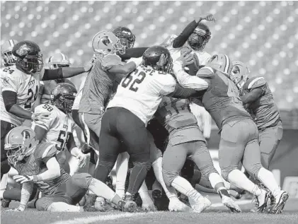  ?? ULYSSES MUÑOZ/BALTIMORE SUN ?? City’s Michael Bond scores the winning touchdown on a quarterbac­k sneak late in the fourth quarter. The Knights rallied for a 22-18 victory in the 129th meeting of the Baltimore City rivals at M&amp;T Bank Stadium.