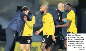  ??  ?? Burton Albion manager Jimmy Floyd Hasselbain­k greets goalscorer Jonny Smith after the final whistle