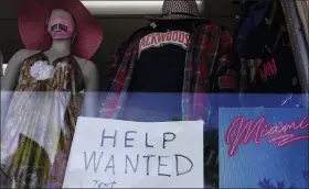  ?? ASSOCIATED PRESS FILE PHOTO ?? A “Help Wanted,” sign is shown in the window of a souvenir shop, Thursday, in Miami Beach, Fla.